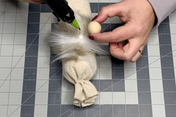 Close up image showing step 9 of the drop cloth farmhouse gnome pattern which is to add a gnome nose to the gnome beard.