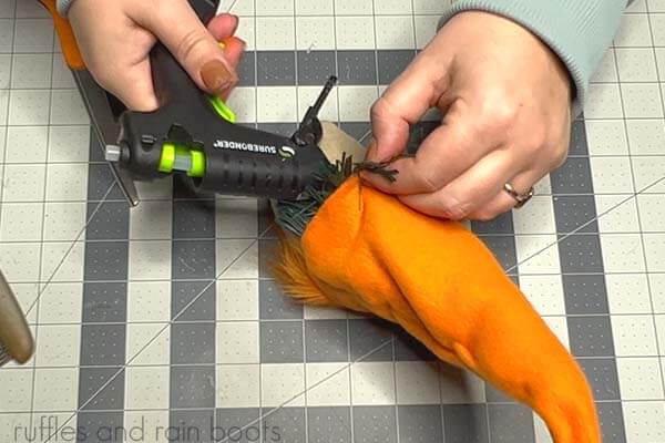 The image shows the last step in the creation and assembly of the carrot gnome which is to glue on the hat to the gnome body.