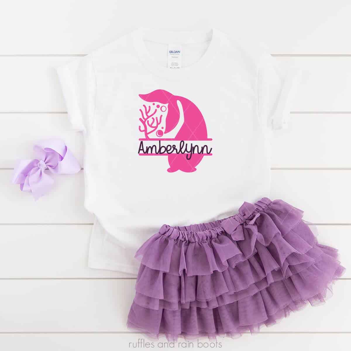 Square image showing a purple hair bow, purple tulle skirt, and white t shirt with coral and mermaid tail monogram cut file in pink vinyl.