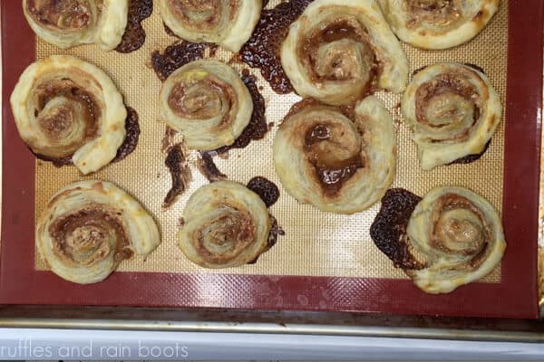 Horizontal image showing baked peanut butter and jelly pinwheel sandwiches.