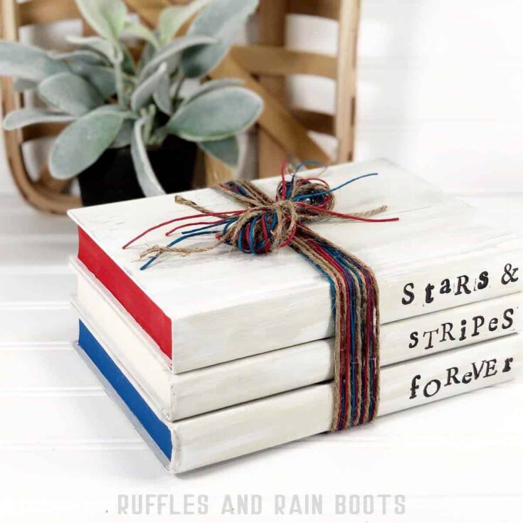 Square image showing the detail on the red, white, and blue book stack for July 4th decorations including red, blue and natural twine, paint, and stamps.