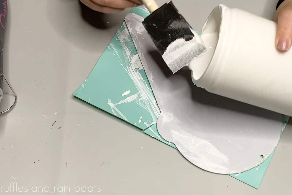Crafter painting an ice cream sign with white gesso acrylic paint.