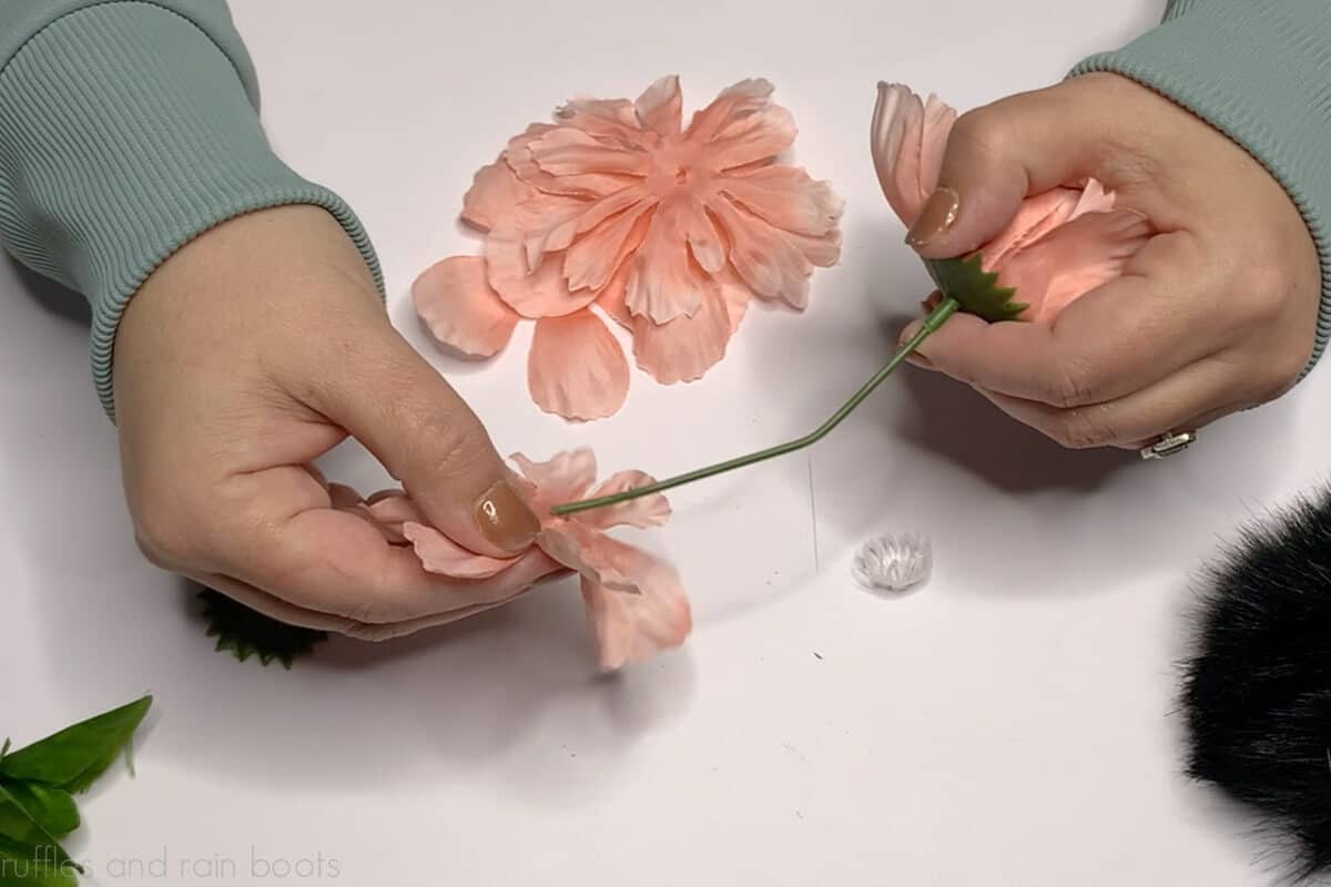 Crafter building a fuller flower gnome hat using two faux florals.