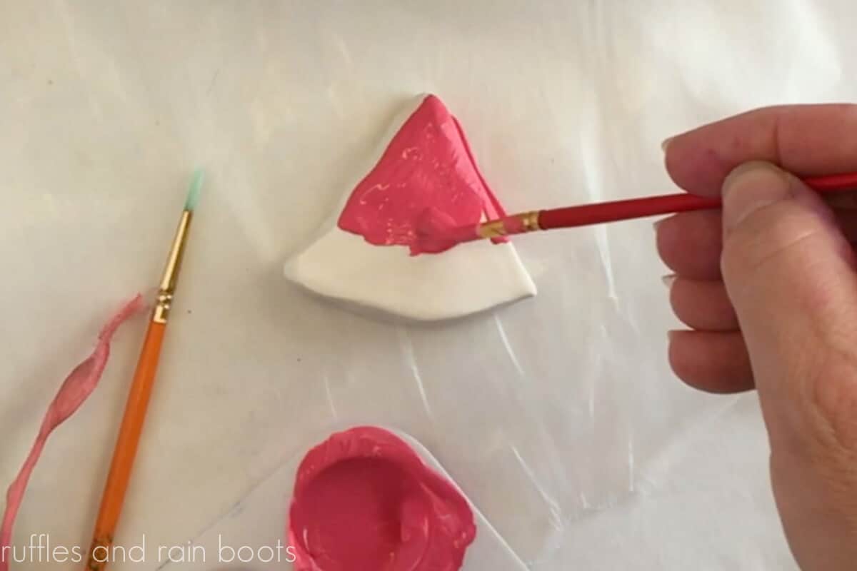 Crafter painting the Model Magic watermelon slice pink with a small paint brush.