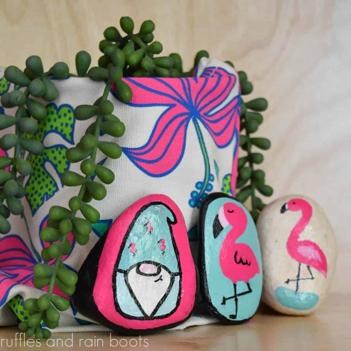 Square close up image of three flamingo rock painting ideas in Kawaii style.