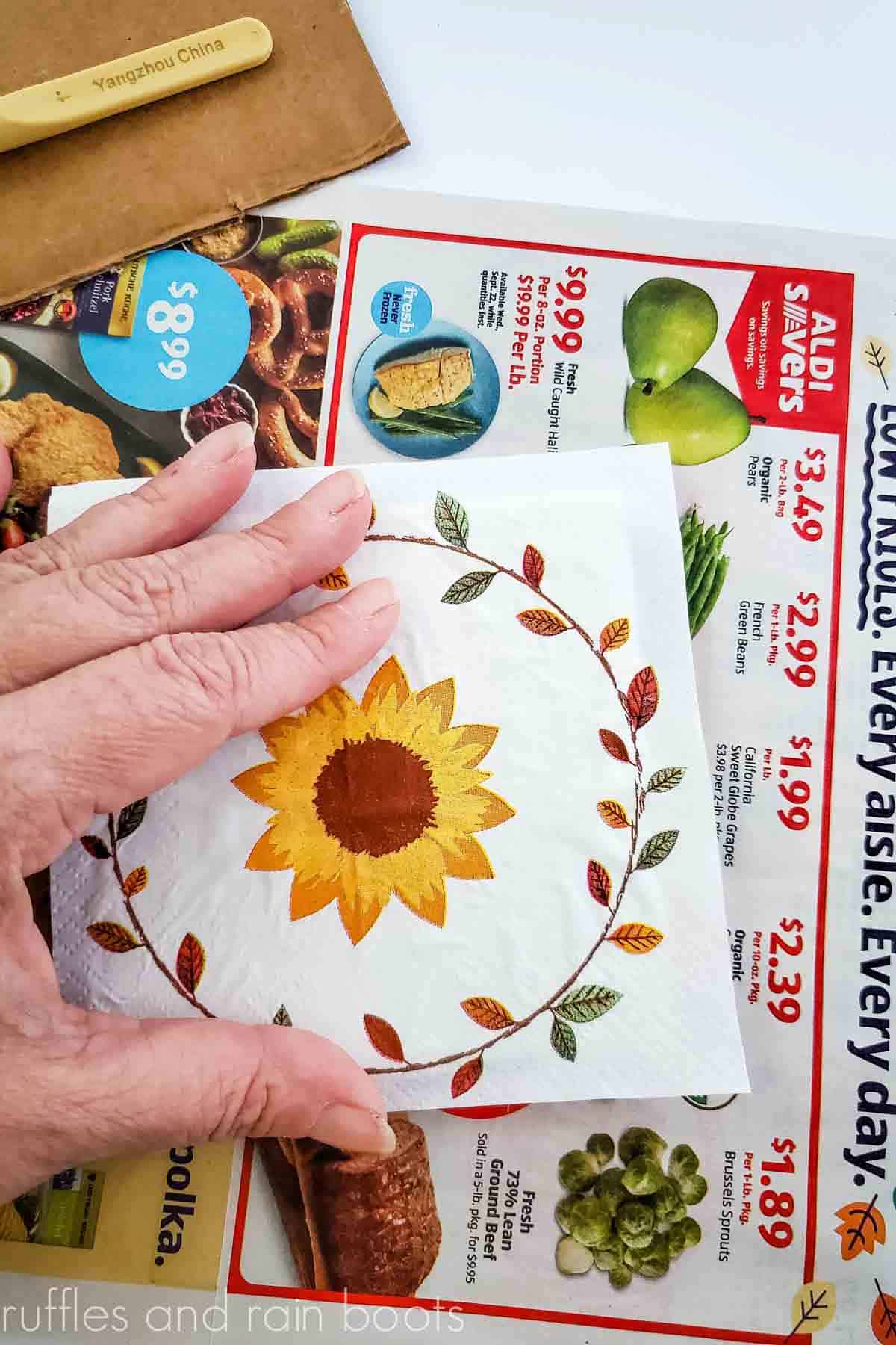 Crafter aligning a sunflower napkin image onto a piece of tile to create a set of DIY coasters.