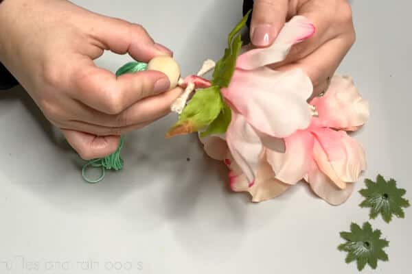 Crafter putting each flower piece over the legs and up to the waist before gluing.