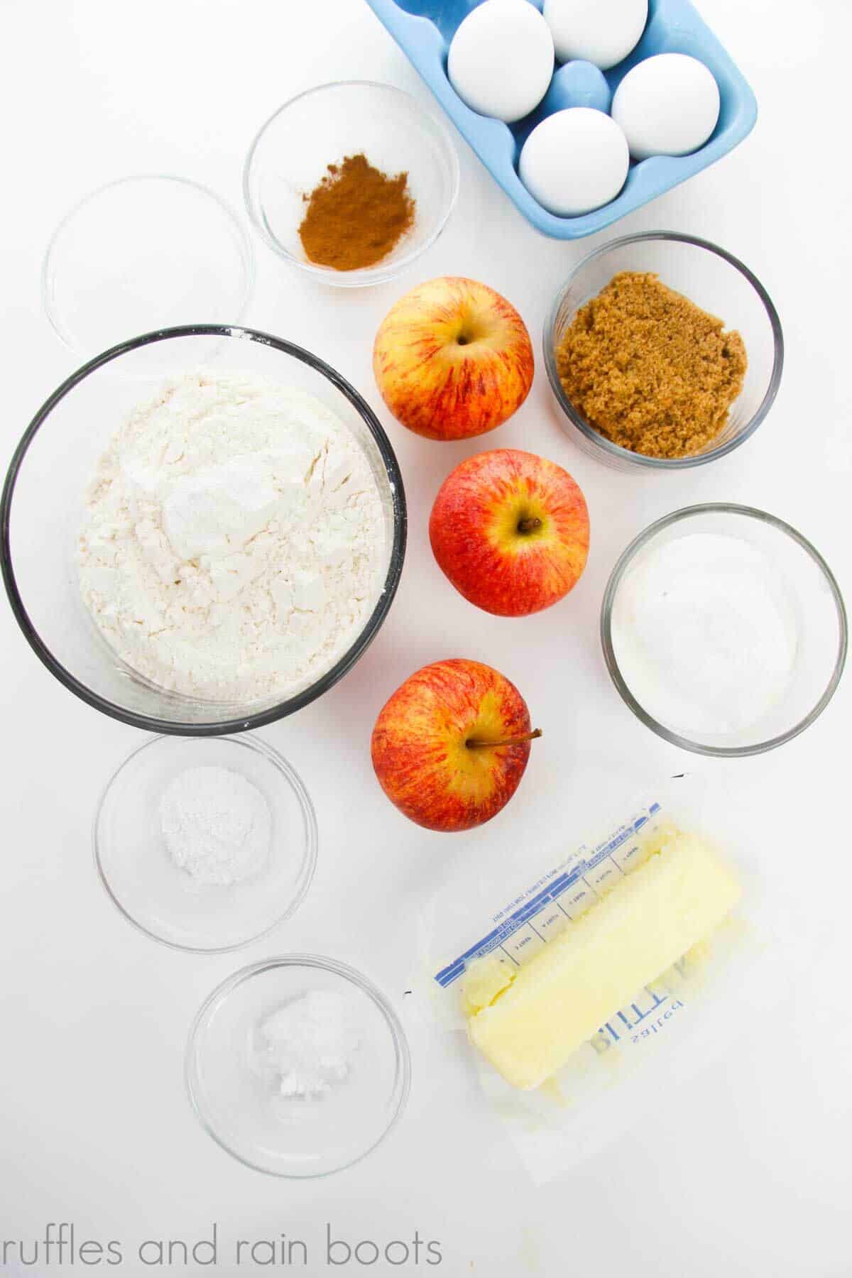 Ingredients needed for a fall muffin recipe with apples, cinnamon, and a crumb topping.