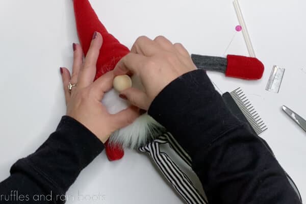 Crafter gluing on a wood ball to make a gnome nose.