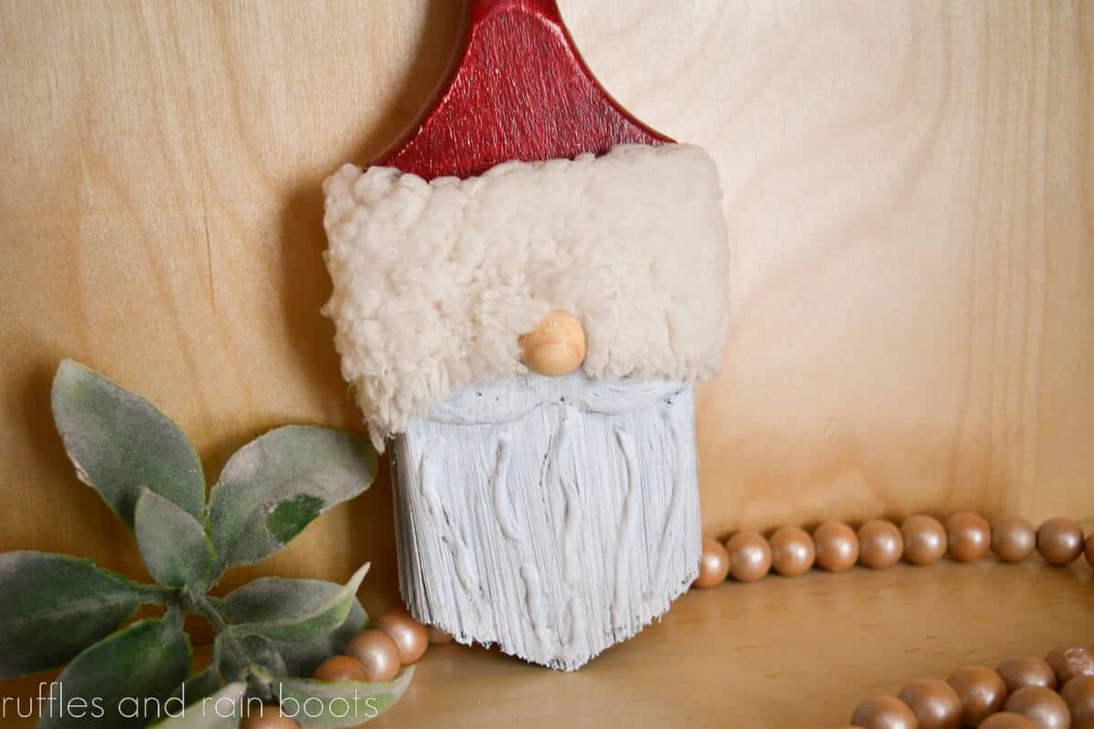 Horizontal image close up of a vintage Santa paintbrush gnome with a Sherpa hat and dimensional beard.