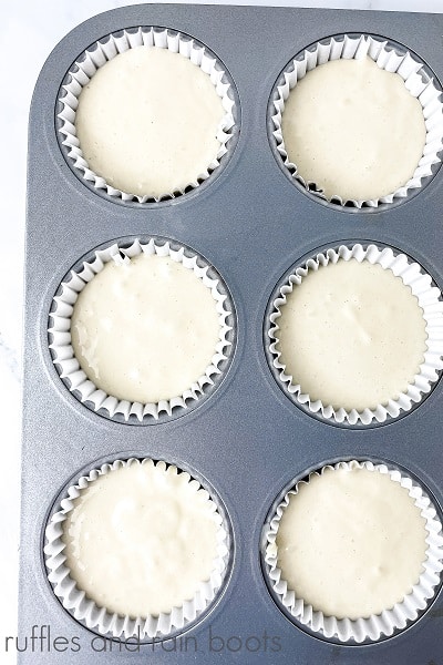 V Overhead image of the batter in the prepared muffin tin for the Hedwig Cookies and Cream Cupcakes on a marble surface.