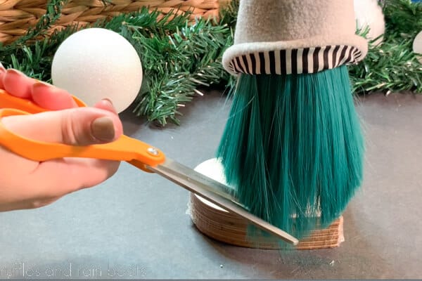 Crafter using very sharp scissors to trim a gnome beard made of doll hair.