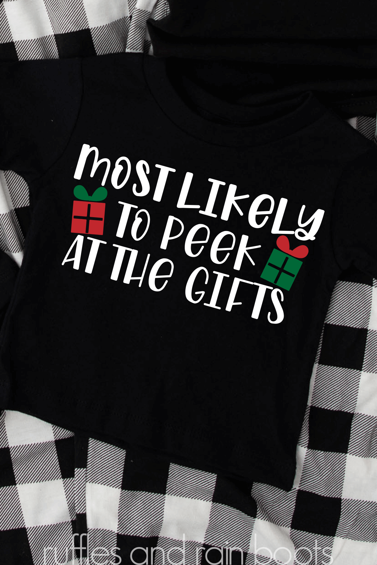 Vertical image of black pajama shirt with white vinyl reading most likely to peek at the gifts.