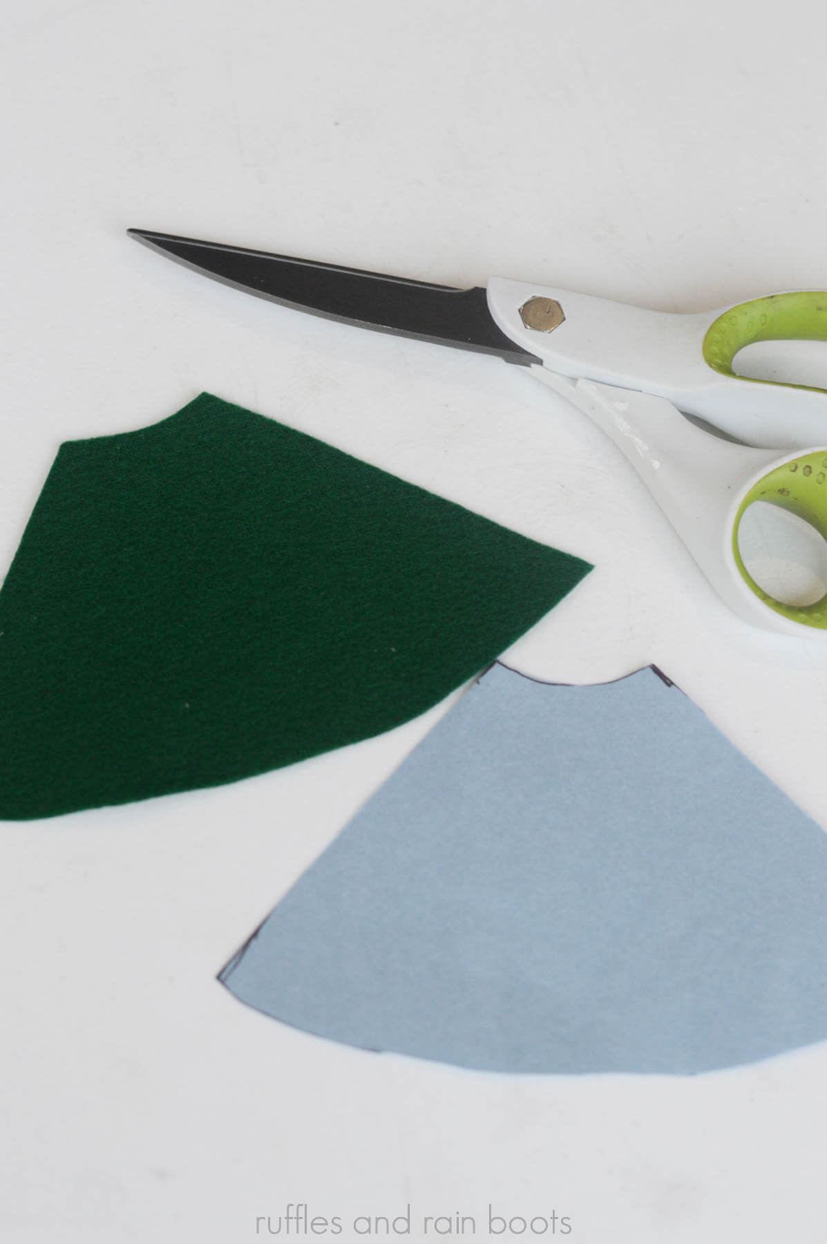Image showing scissors and felt cut in a gnome hat shape on white background.