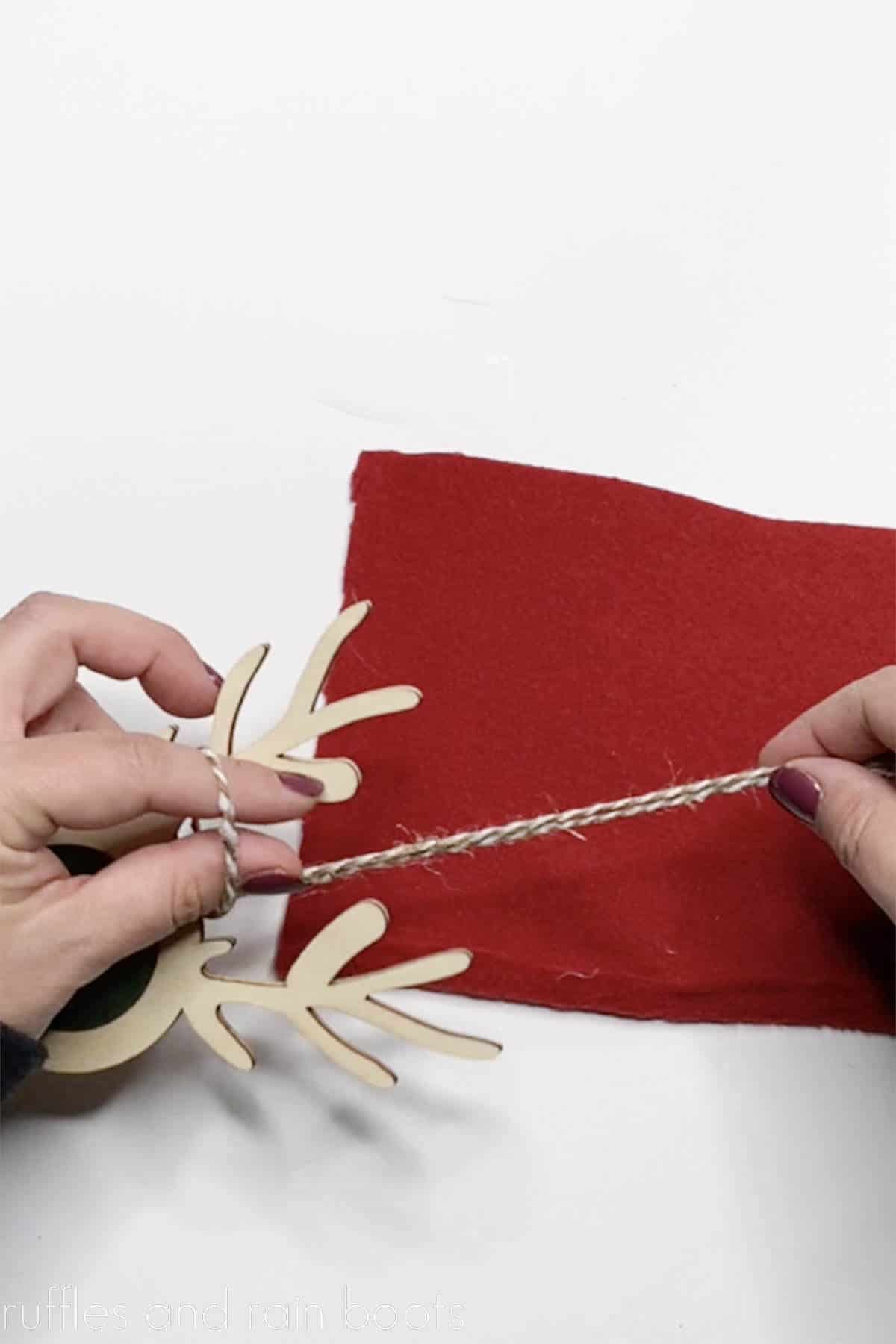 Crafter tying on a long piece of bakers twine for an ornament hanger.