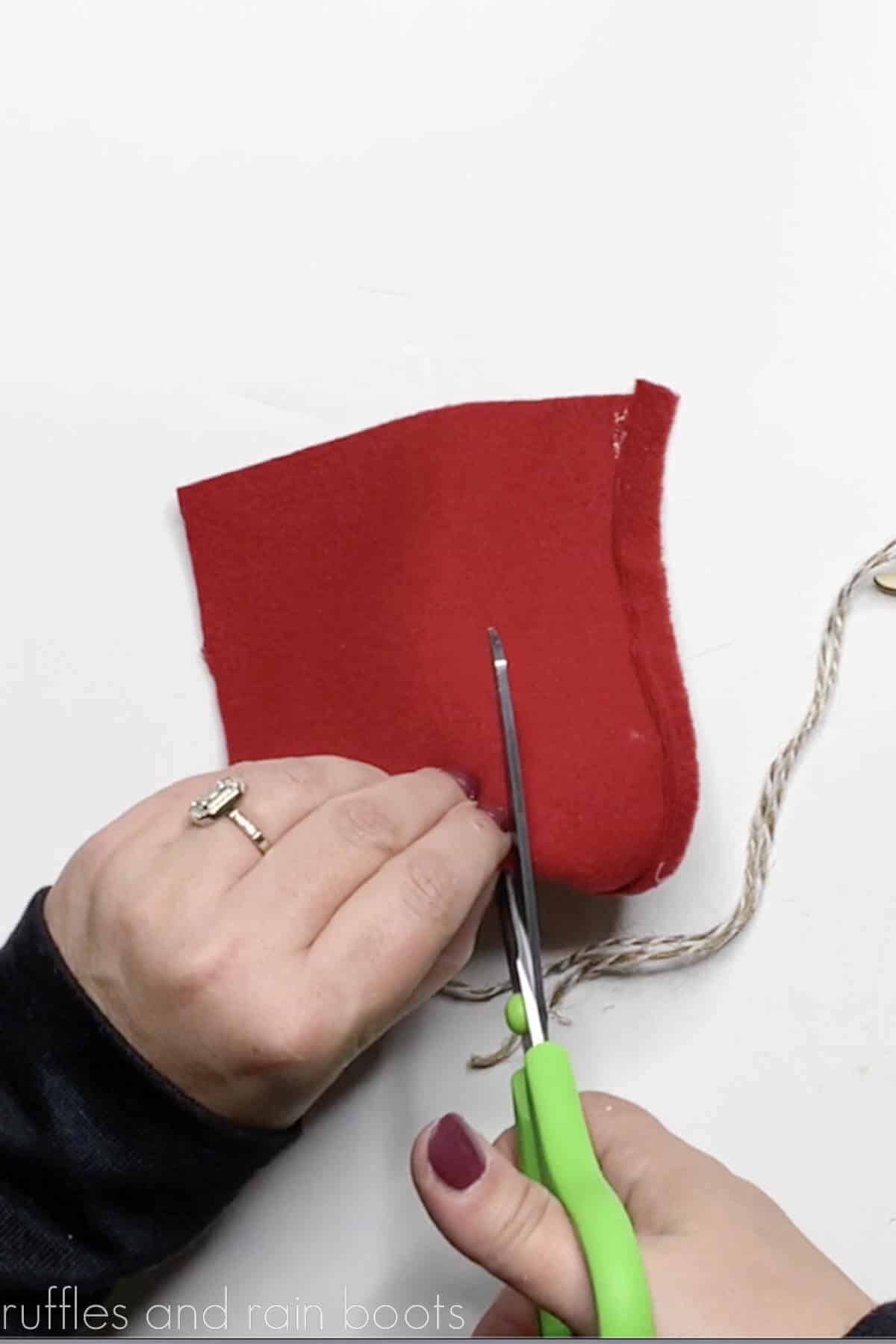 Crafter cutting into a red fleece fabric to make a gnome hat for a reindeer.