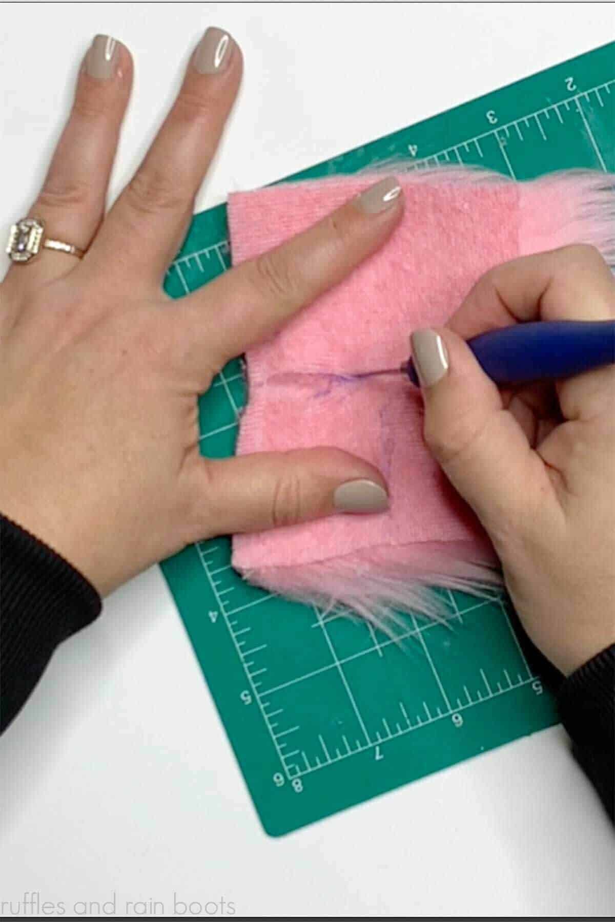 Crafter using an X-acto to cut a faux fur square for a Valentine's Day gnome.