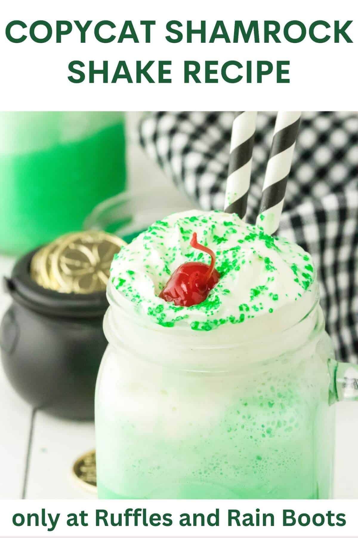 Close up of Copycat Shamrock Shake in a mason jar glass with a black pot of faux gold and a black and white napkin in the background on a white weathered wood surface.