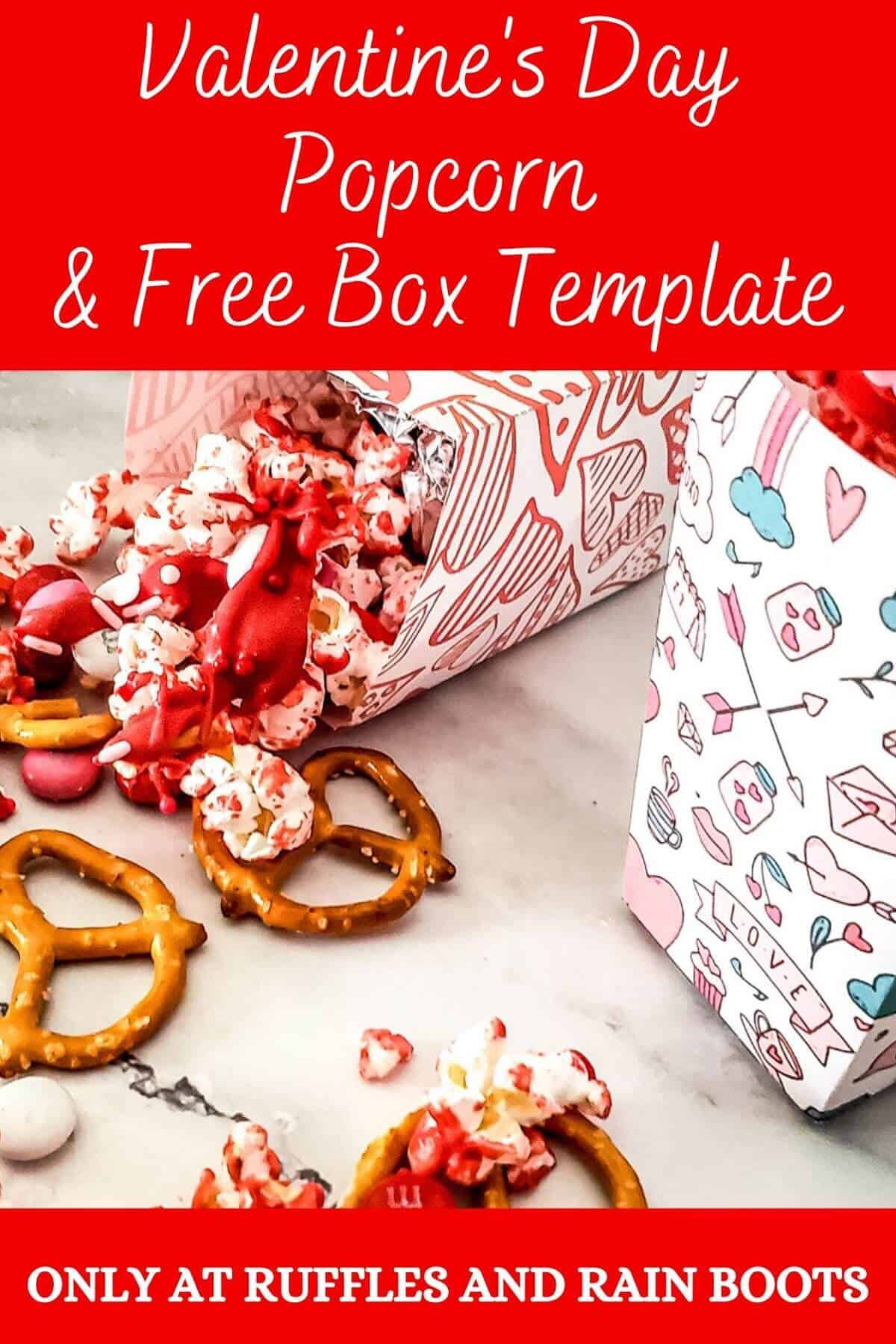Image with 2 white vertical boxes, with one laying down, printed with Valentine's style patterns, filled with popcorn mix with some of the mix scattered on a marble surface.