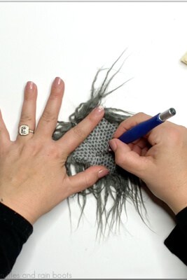 Crafter using an X-Acto to cut faux fur into pieces for a farmhouse cow face.