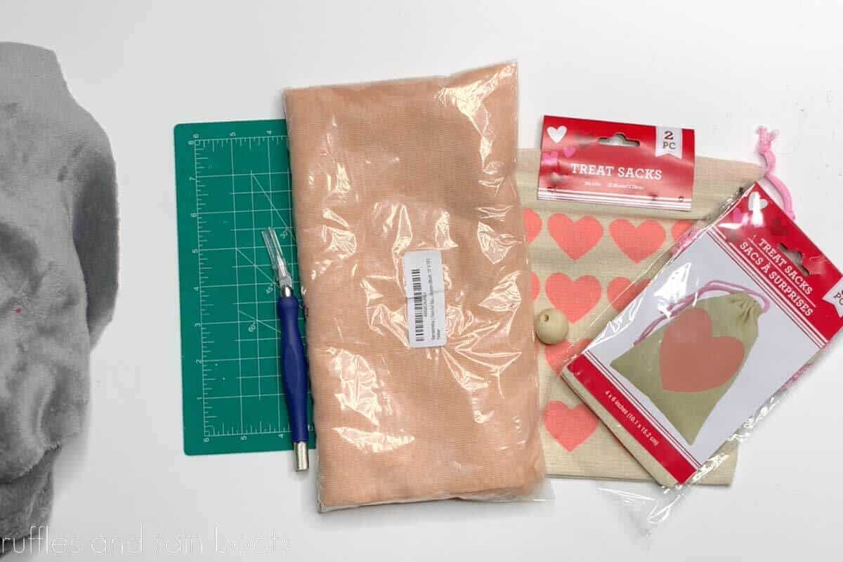 Horizontal image of supplies to make a gnome including treat bags, fur, and fabric.