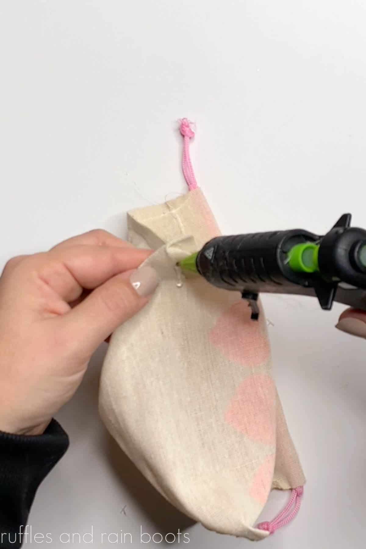 Crafter gluing the corners of a treat bag with hot glue.