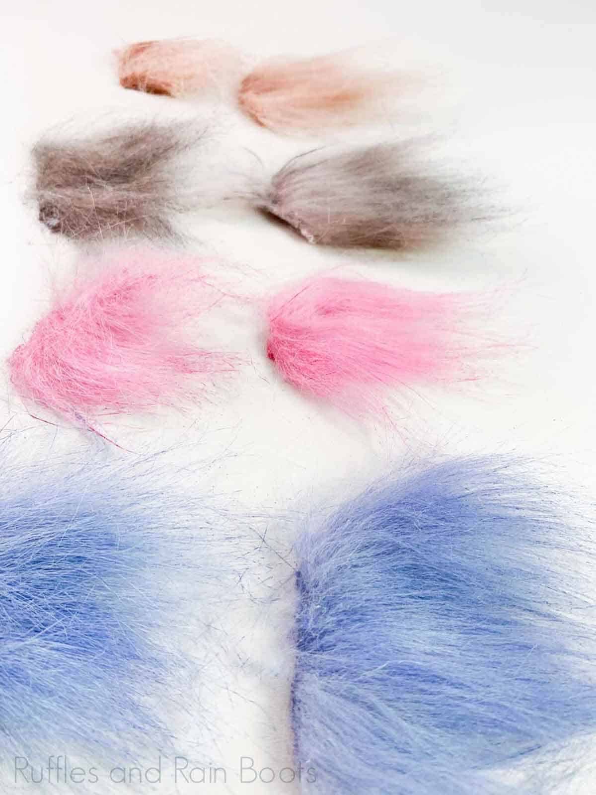 Vertical image of four dyed fur samples using acrylic paint and a brush.