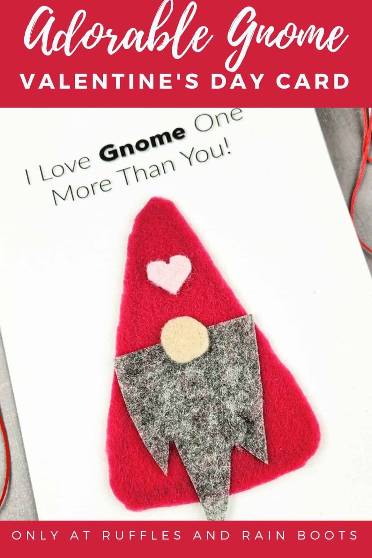 Cute easy Valentine’s Day Gnome card on a gray concrete surface surrounded by coloful string.