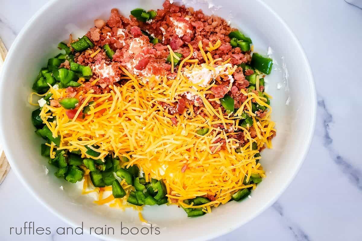 Jalapeno Popper Pinwheel Sandwiches mixture in a round white bowl on a white marble surface.