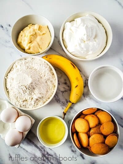 Ingredients for the banana cream pie cupcakes on a white marble background