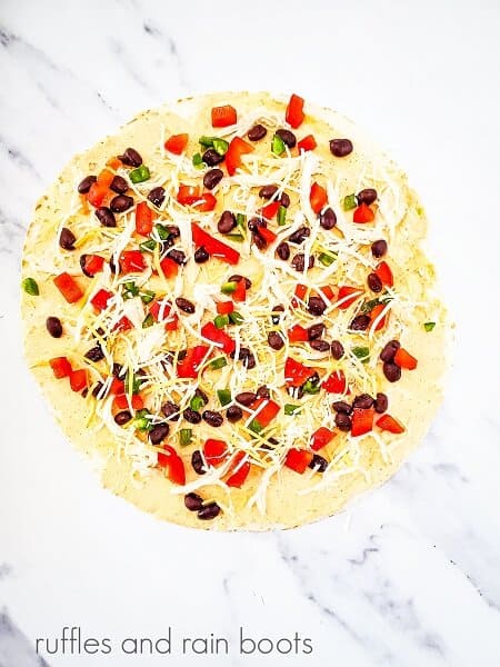 Open-faced Mexican fiesta pinwheel sandwich with all the ingredients on a white marble background.