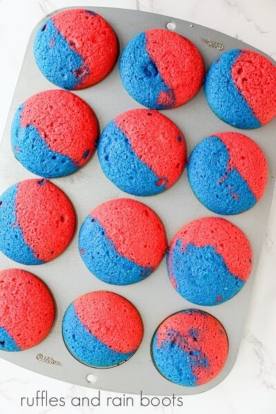 A pain of baked patriotic USA cupcakes in a baking pan on a white marble surface