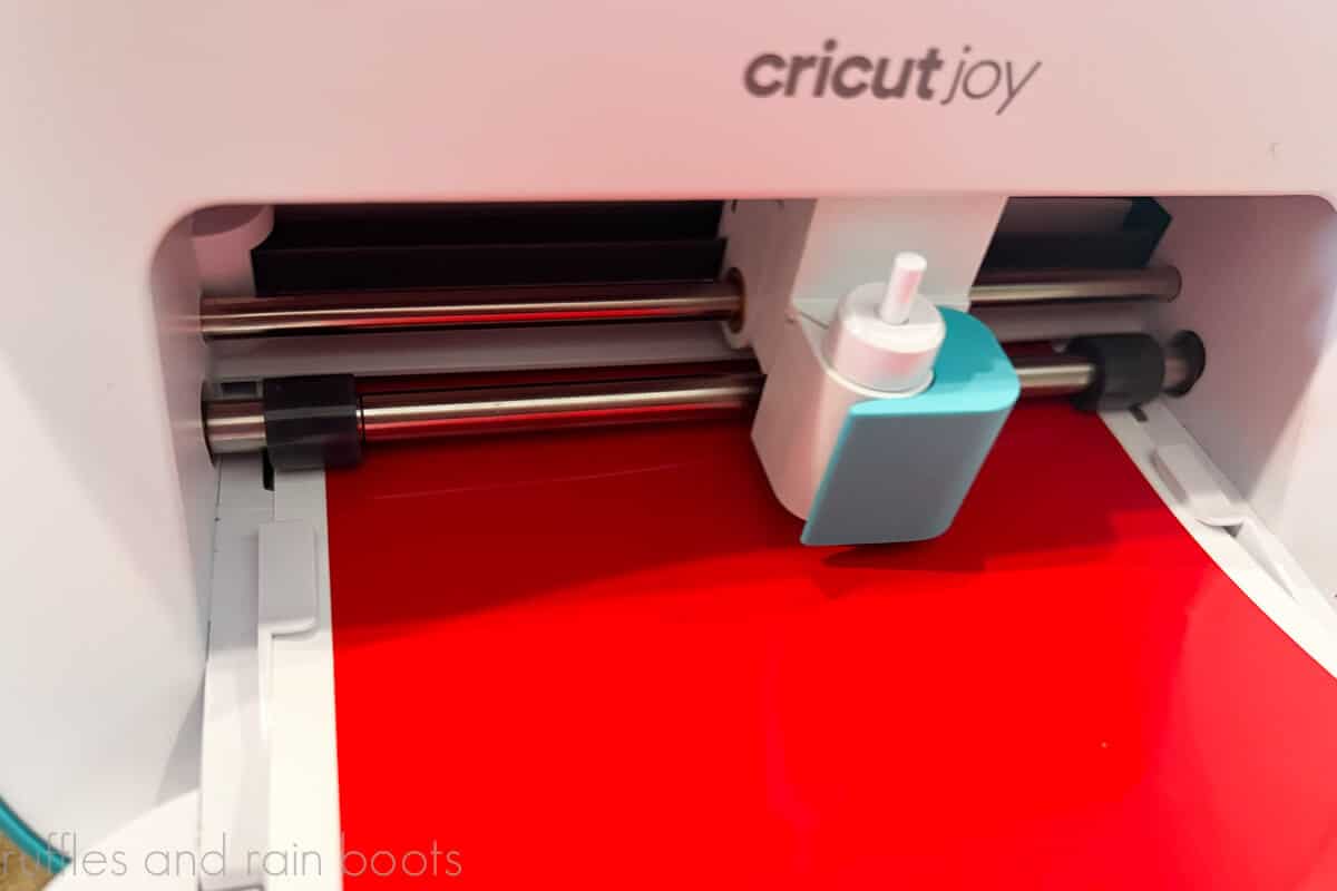 Cricut Joy cutting permanent Smart Vinyl into heart shaped SVG with text.