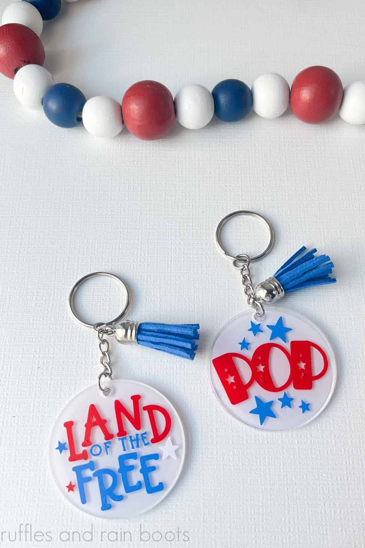 Vertical image of two clear acrylic keychains with 4th of July SVG free files from Ruffles and Rain Boots.