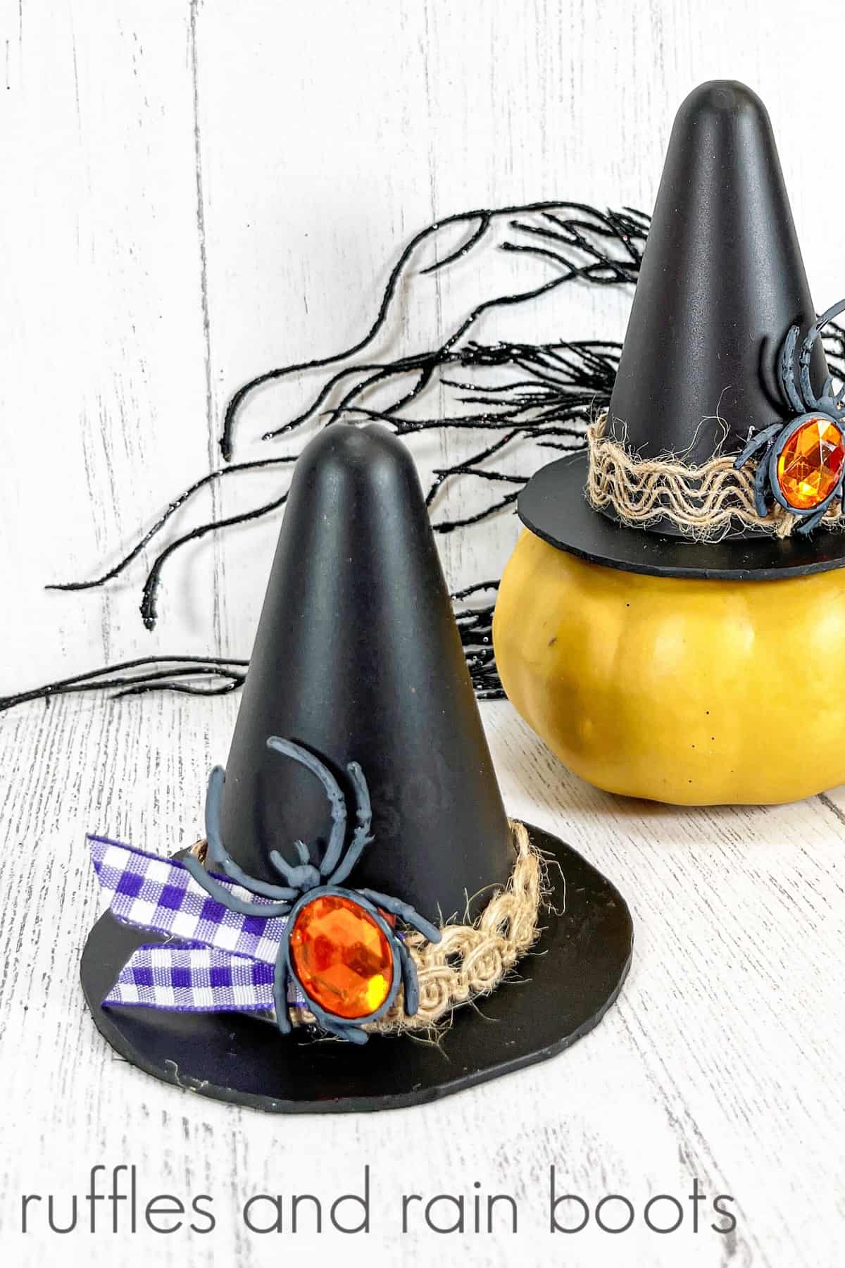 A completed witch's hat in the foreground, next to a completed witch's hat on top of a yellow gourd against a white weathered wood background.