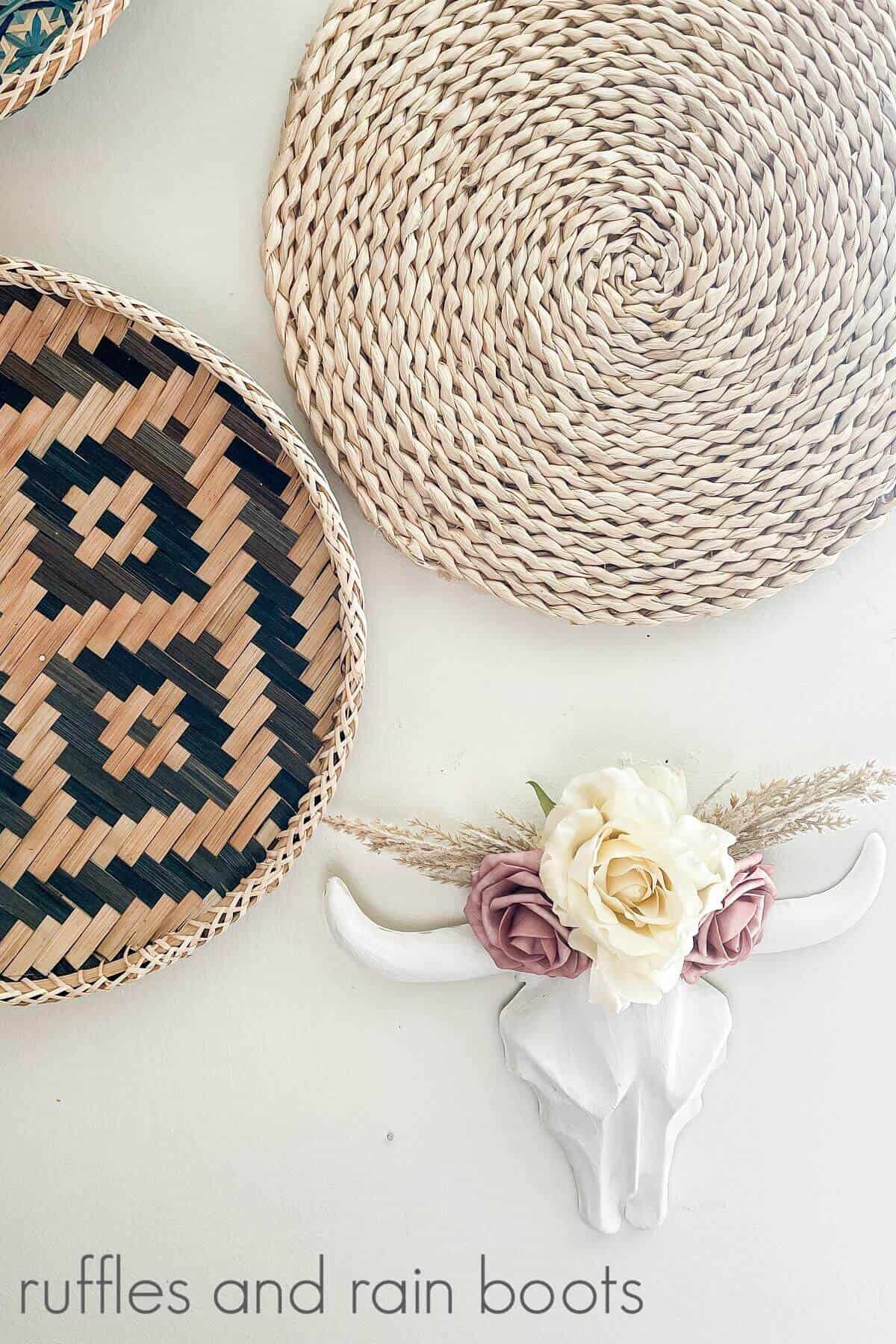 A decorated plastic steer skull next to woven baskets against a white background.