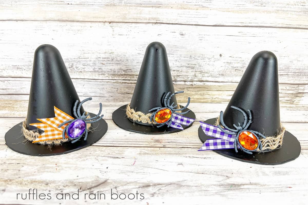 Three completed witches hats against a white weathered wood background.