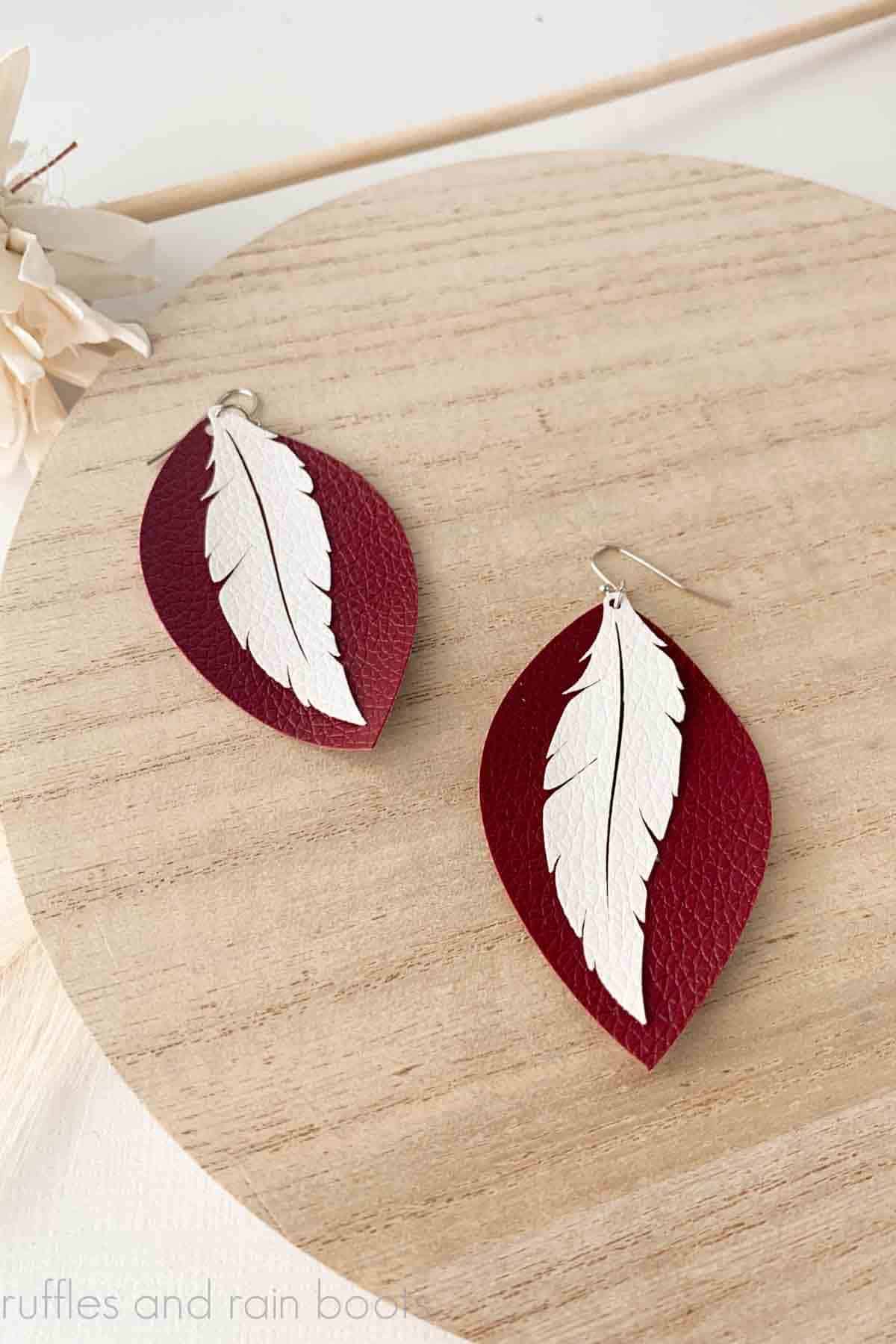 Vertical image of layered feather earrings made with the xTool M1 laser and blade cutter and faux leather.
