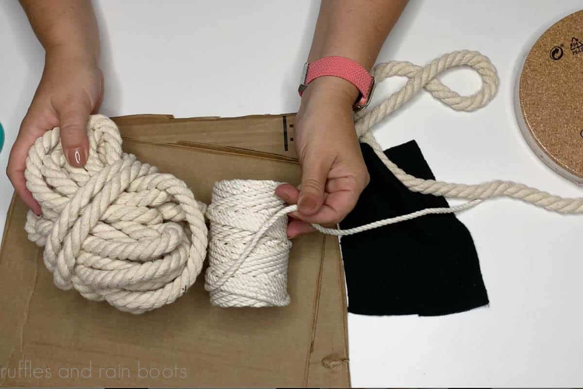 Horizontal image of crafter showing supplies of rope, cardboard, and fabric needed for a rope ghost DIY.