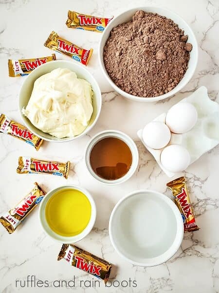 The ingredients for Twix candy cupcakes on a marble background.