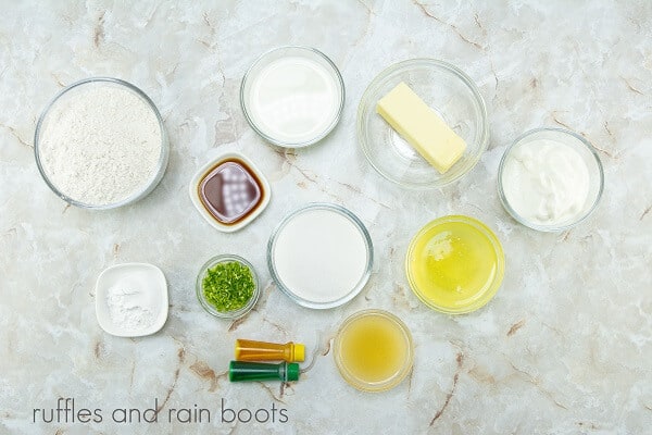 The ingredients for the slime cupcakes against a white marble background.