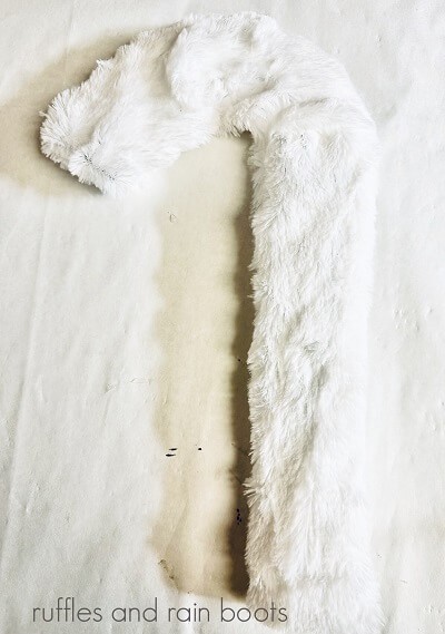 A candy cane shaped wrath form covered in white fur against a white background.
