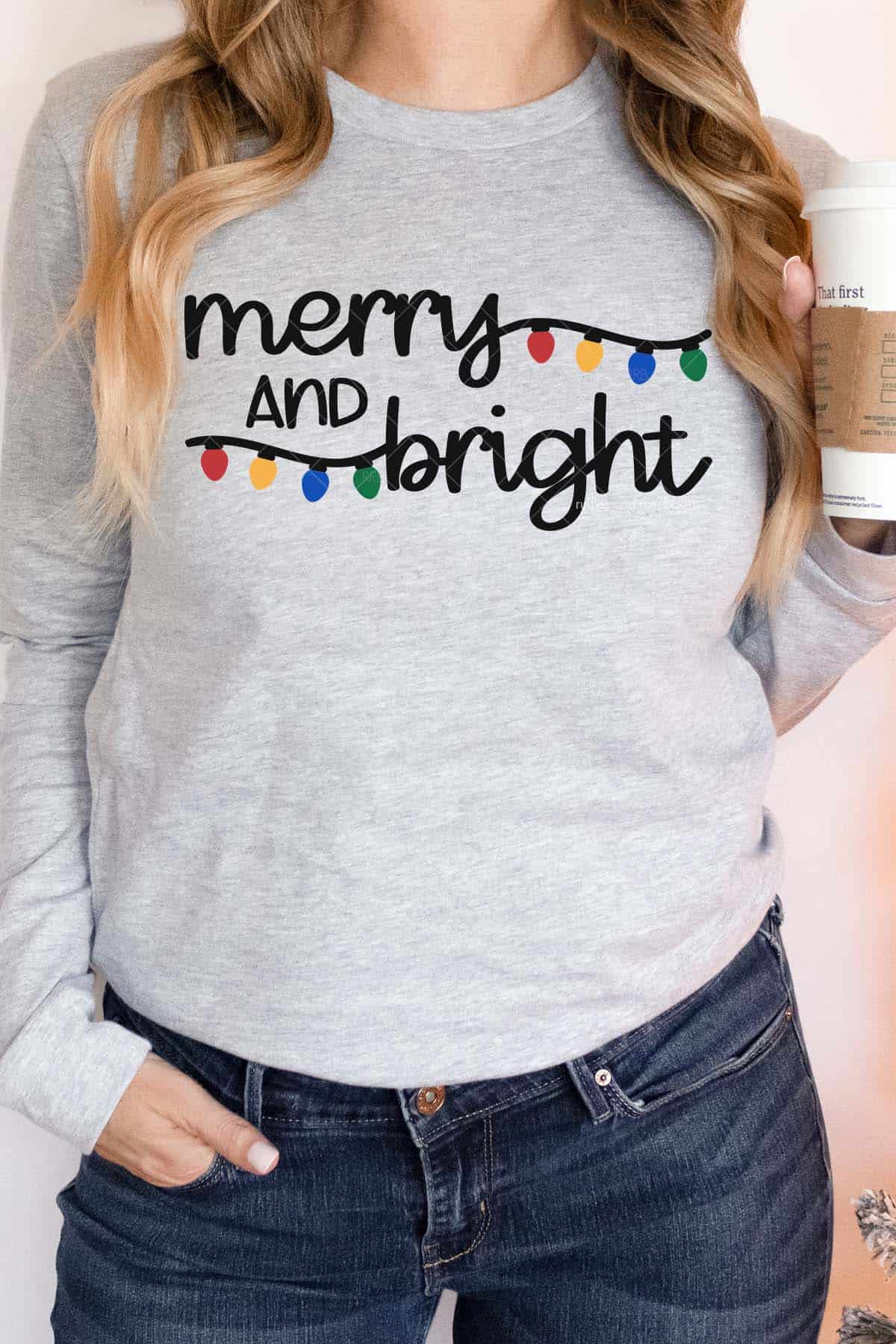 Vertical image of woman in jeans and gray sweatshirt with colorful Christmas lights SVG which reads merry and bright in black HTV.