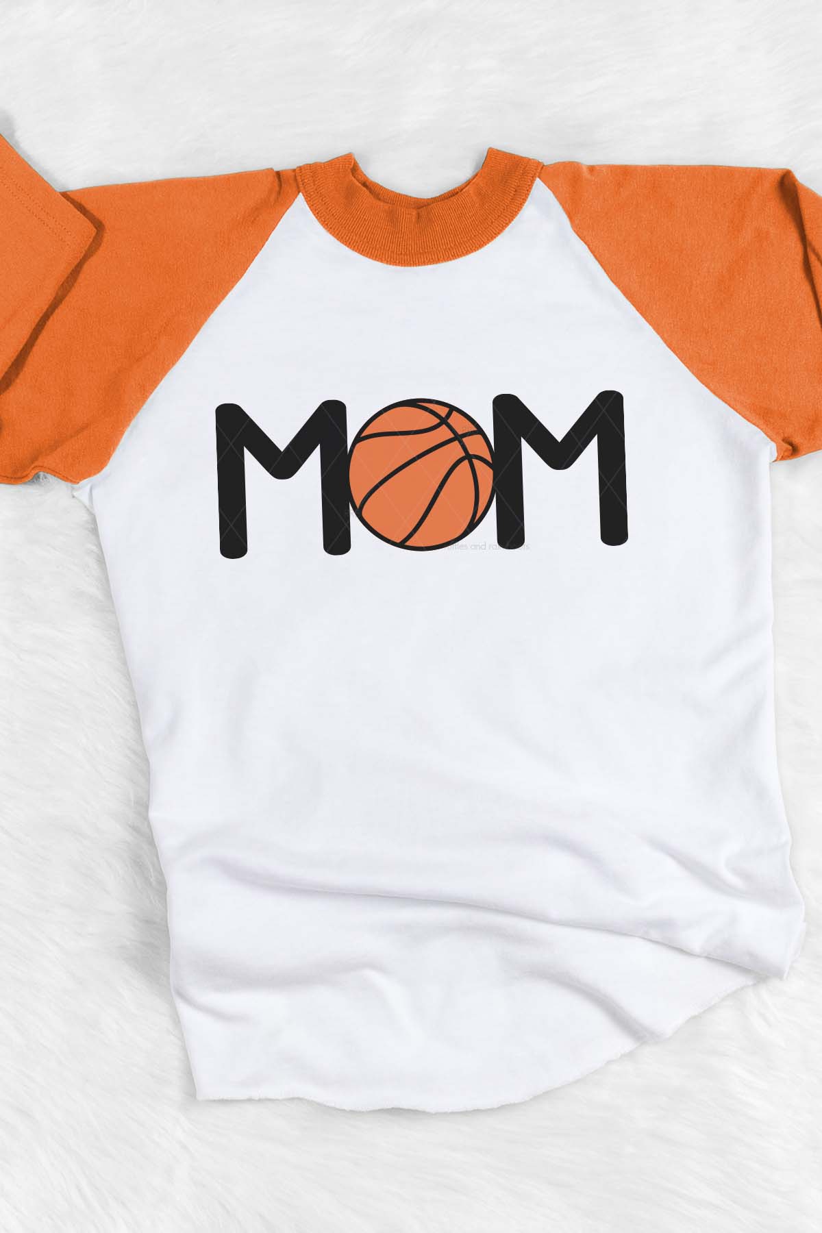 Vertical image of a white shirt with orange sleeves with a MOM with a basketball in orange and black heat transfer vinyl.