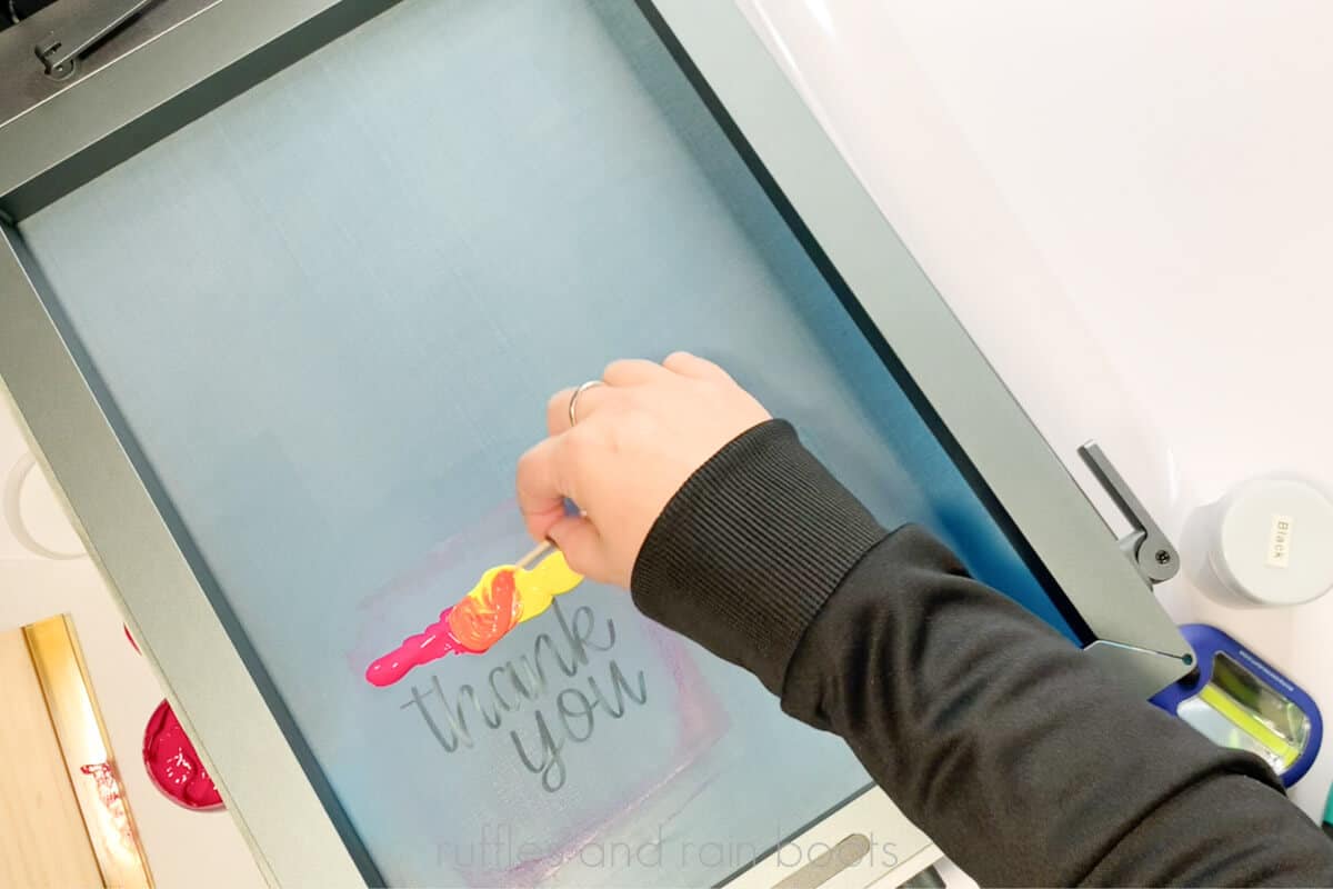 Horizontal image of crafter blending paint on the xTool screen printer set up.