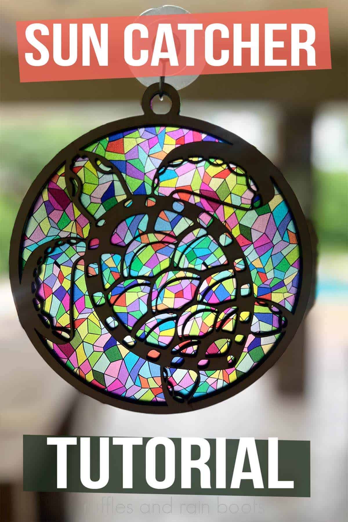 Vertical image of a colorful sun catcher made with a laser hanging on a suction cup hook with text which reads sun catcher tutorial.
