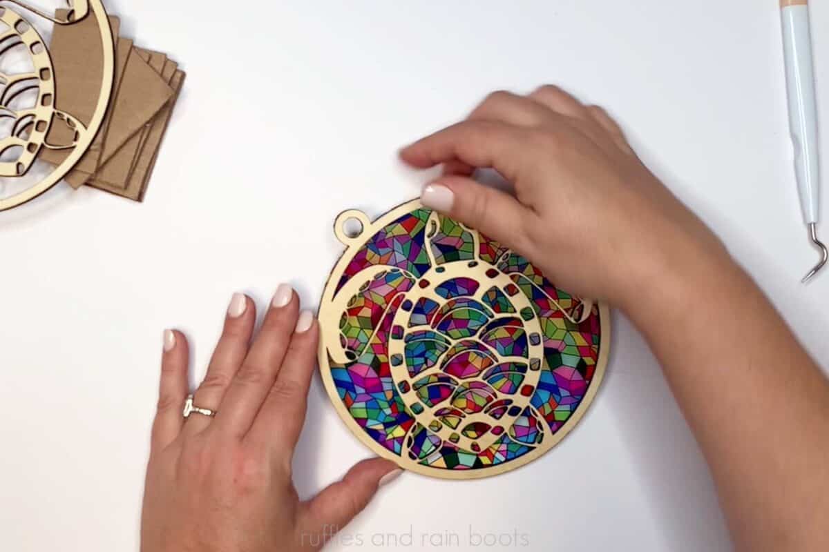 Horizontal image of a crafter assembling a laser cut sun catcher.