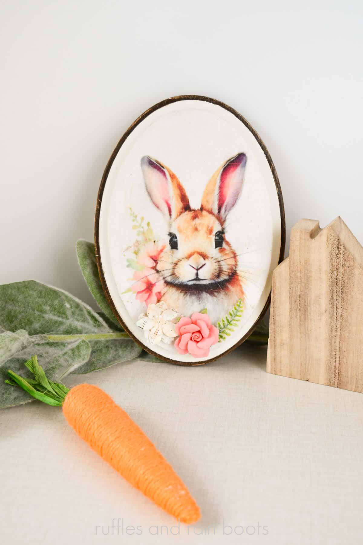 Vertical image of mulberry paper printed rabbit with flowers decoupage onto a dollar store plaque.