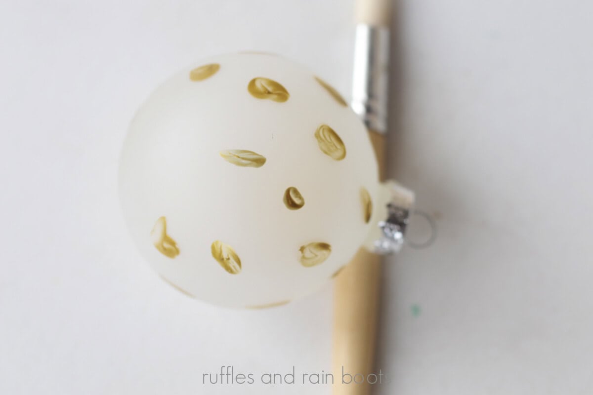 Crafter showing the organic shapes painted in gold paint for the leopard print step one.