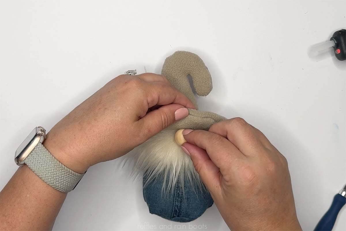 Crafter adding a beard and nose to a quick, no sew summer gnome.